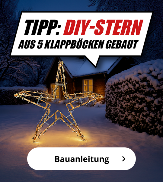 Winterliche Gartenszene mit beleuchtetem DIY-Stern aus fünf Klappböcken, umwickelt mit Lichterketten. Im Hintergrund steht ein Haus mit beleuchtetem Fenster. Text im Bild: „Tipp: DIY-Stern aus 5 Klappböcken gebaut“. Schaltfläche mit der Aufschrift „Bauanleitung“.